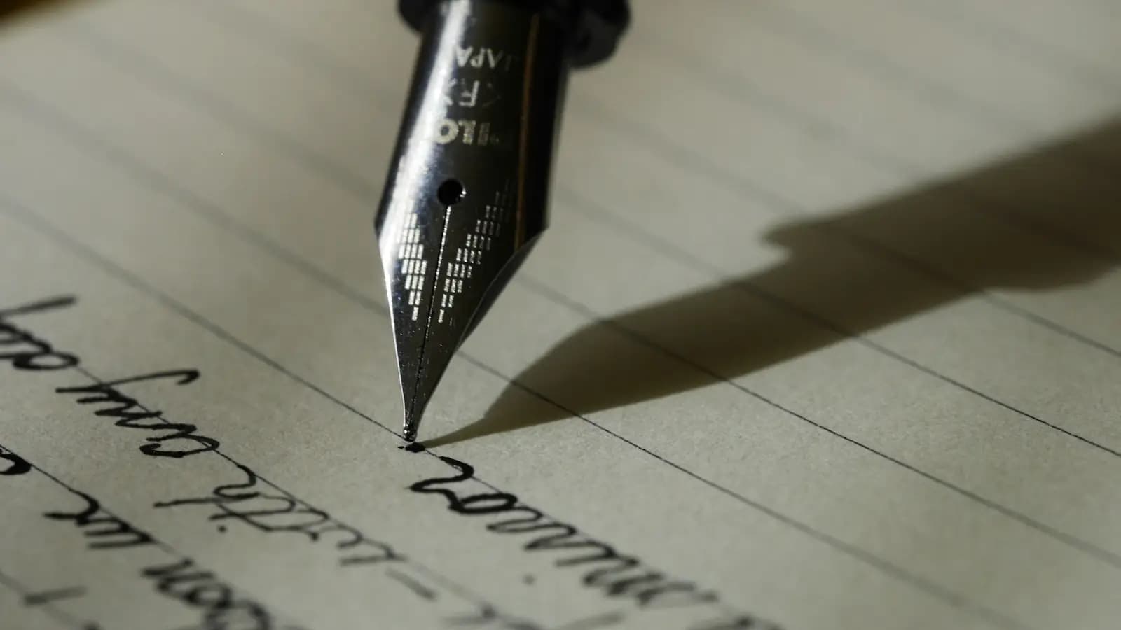 Plume de stylo à encre en train d'écrire sur une page lignée